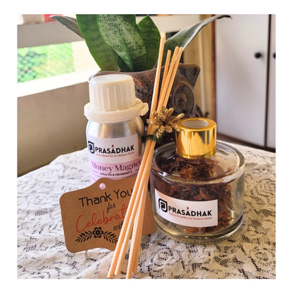 Money Magnet reed diffuser set: white-cap bottle labeled Money Magnet, jar of botanicals, beige reeds, gold cap.