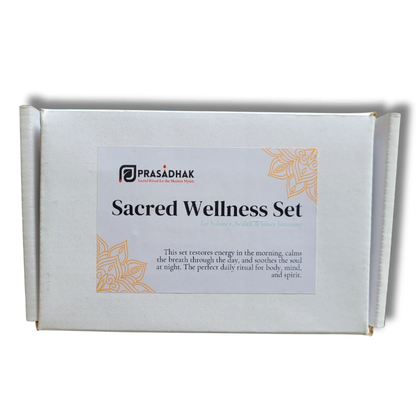 White box with a label reading Sacred Wellness Set, black text, orange decorative corners, and a PRASADHAK logo.