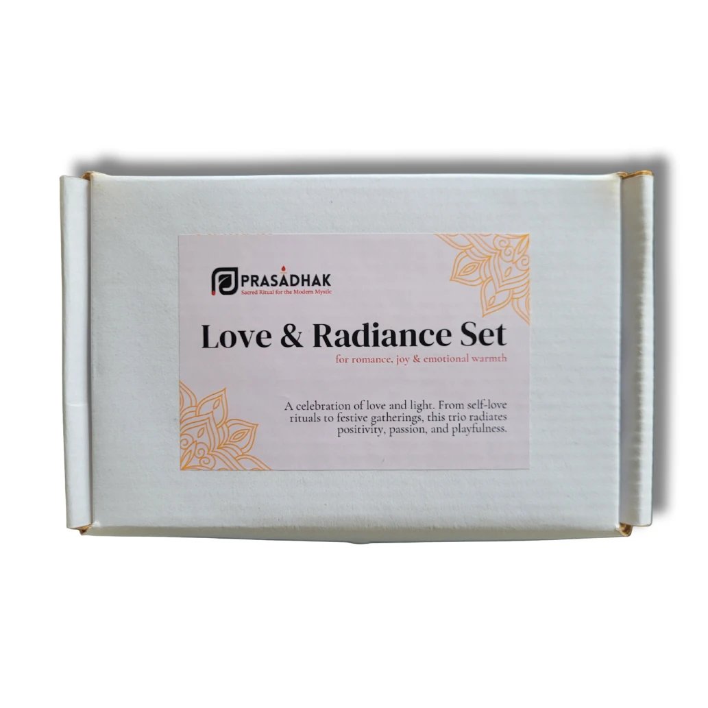 White box with pale pink label reading Love & Radiance Set by PRASADHAK, orange floral corner accents.
