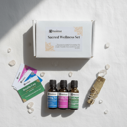 A flat-lay of the Prasadhak Sacred Wellness Set, featuring three essential oil bottles with blue, pink, and green labels
