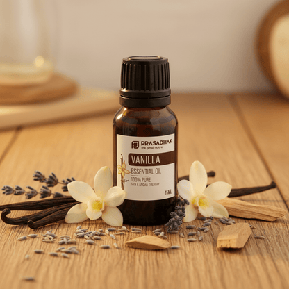 A 10mL bottle of Prasadhak Vanilla Essential Oil on a wooden table, surrounded by vanilla beans, lavender flowers, and lavender buds.